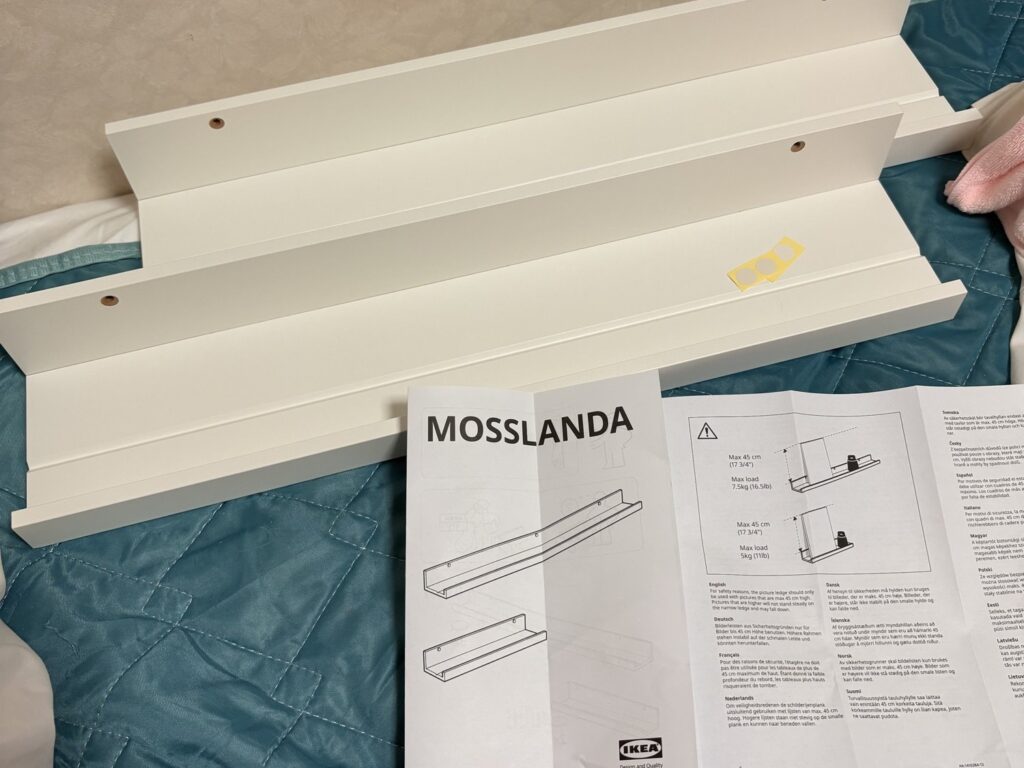 袋から出した白いウォールシェルフMOSSLANDA 2本と説明書