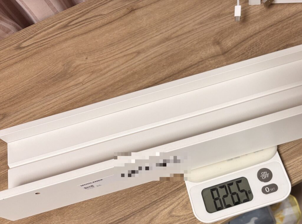 白いウォールシェルフMOSSLANDAをキッチンスケールにのせたところ。表示は826.5g