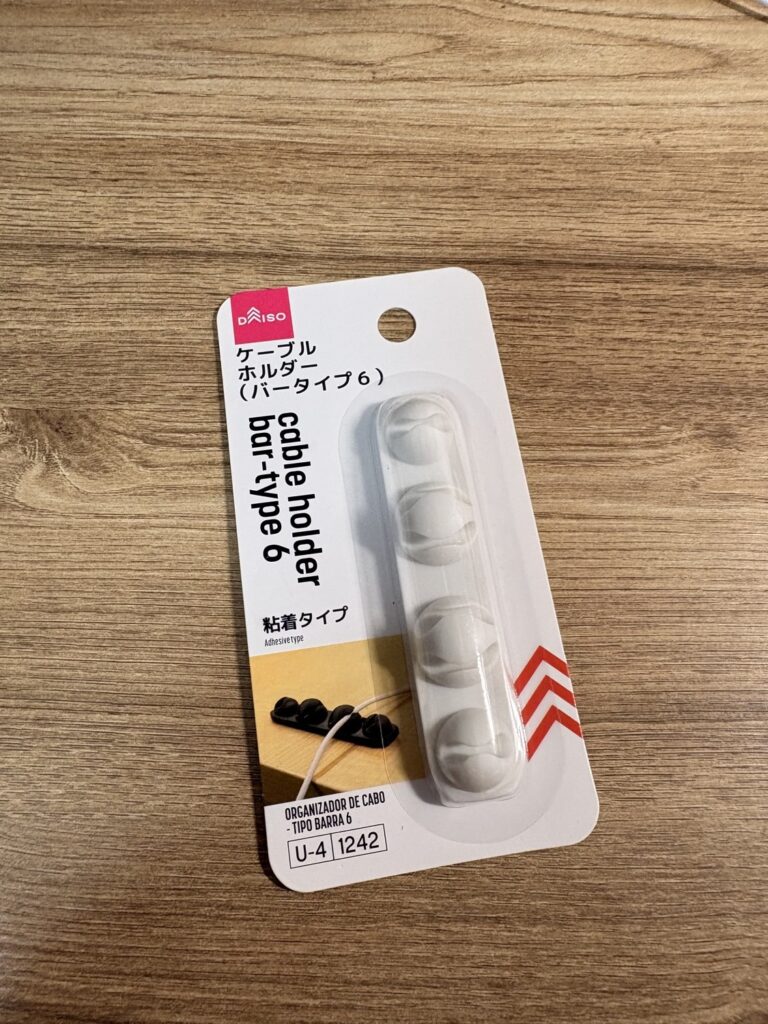 DAISOのケーブルホルダー(バータイプ6)粘着タイプ。白いバーにケーブルをはめるくぼみが並んだパッケージ