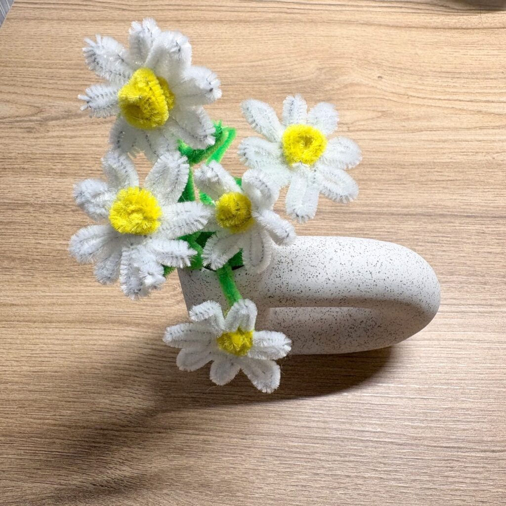 DAISOの白い花瓶に、白・黄色・緑のモールで作ったデイジーを挿したところ