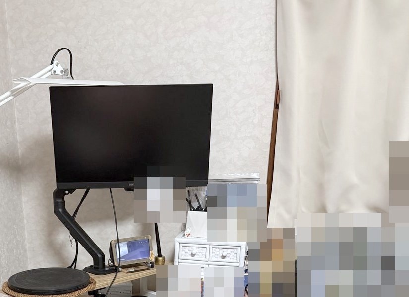 Before：飾る前のデスク横の壁。モニターの右の壁には何も掛かっていない。机の上の物にはモザイク
