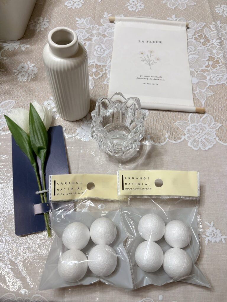 Seriaで買ったアイテムと材料。白いリブの花瓶、白いチューリップの造花、「LA FLEUR」のタペストリー、ガラスのホルダー、発泡スチロール玉（ポリフォームベース ボール4P）2袋