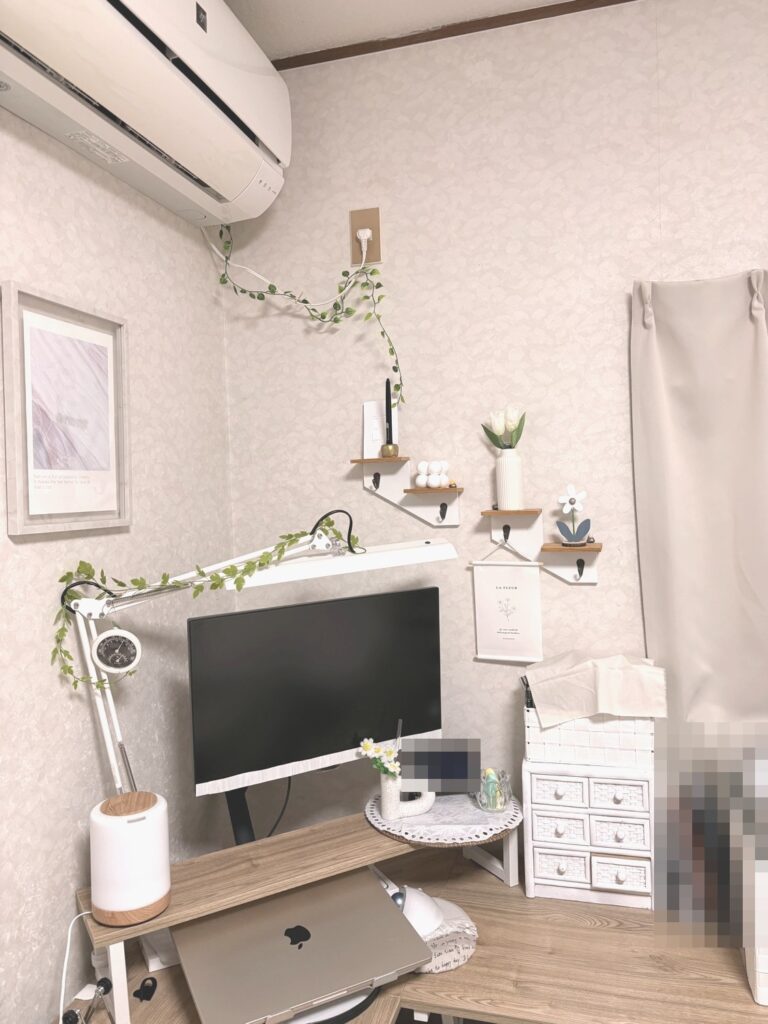 After:エアコンのコードとデスクライトのアームに、明るい緑のガーランドを巻いたデスクまわり