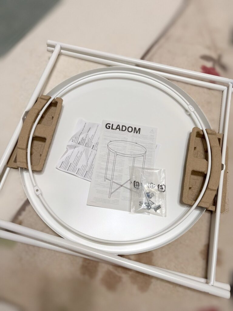 箱から出したIKEAのGLADOM(グラドム)の部品。丸いトレイと白い脚、説明書
