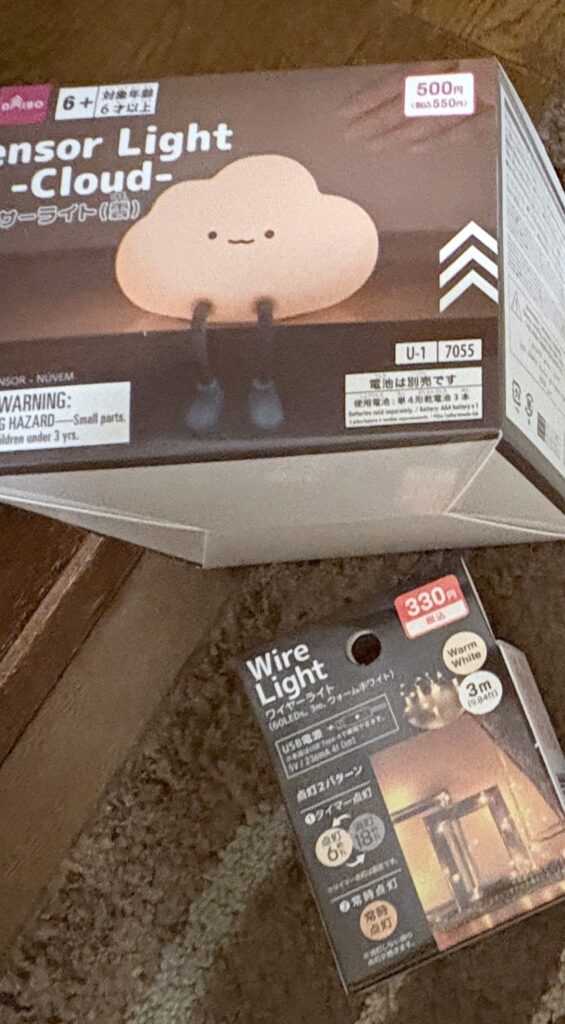 DAISOの雲形センサーライト（Sensor Light -Cloud-、500円）の箱と、ワイヤーライト（Wire Light、330円）の箱