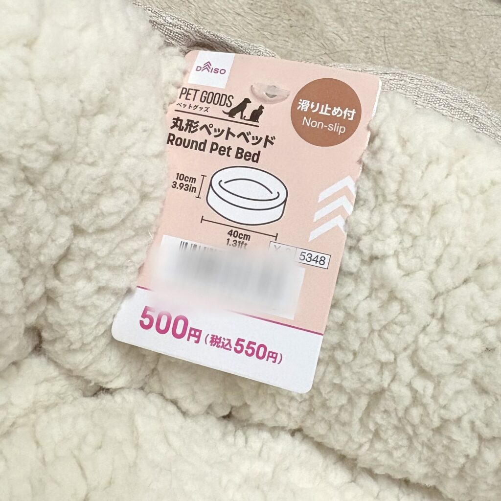 DAISOの丸形ペットベッドの値札。「丸形ペットベッド」「滑り止め付」、直径40cm・高さ10cm、500円（税込550円）と書いてある